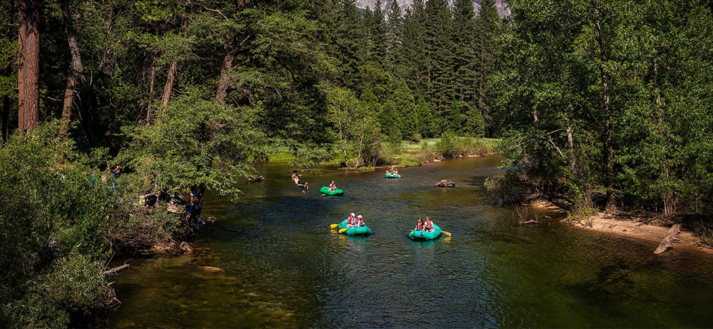 A group paddling inflatable pack rafts on a simple river trip