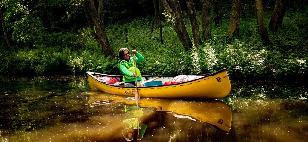 Open Canoe paddler on a still piece of water