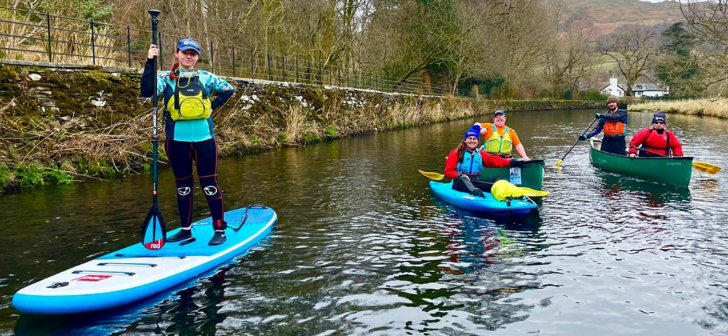 a group on the canal, including a women on a SUP