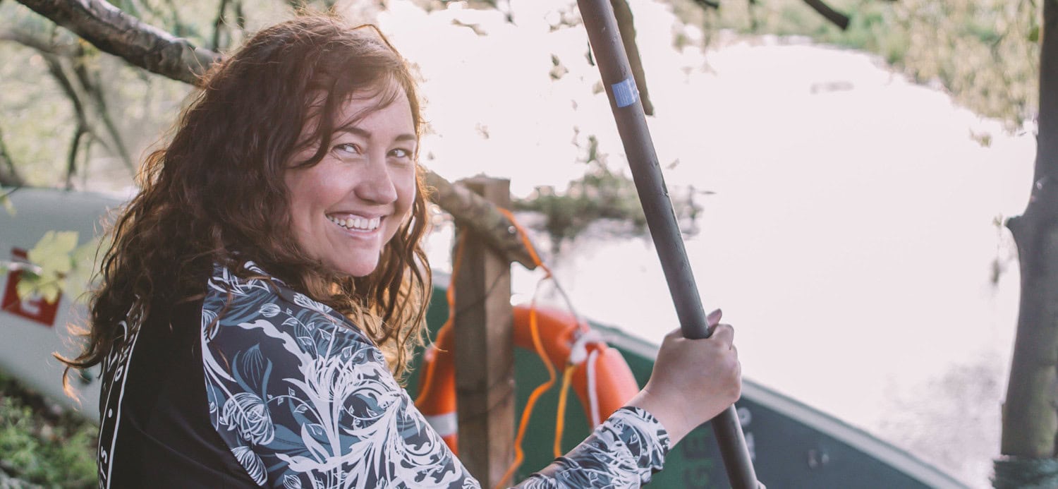 Natasha sat on the side of the bank with her stand up paddleboard